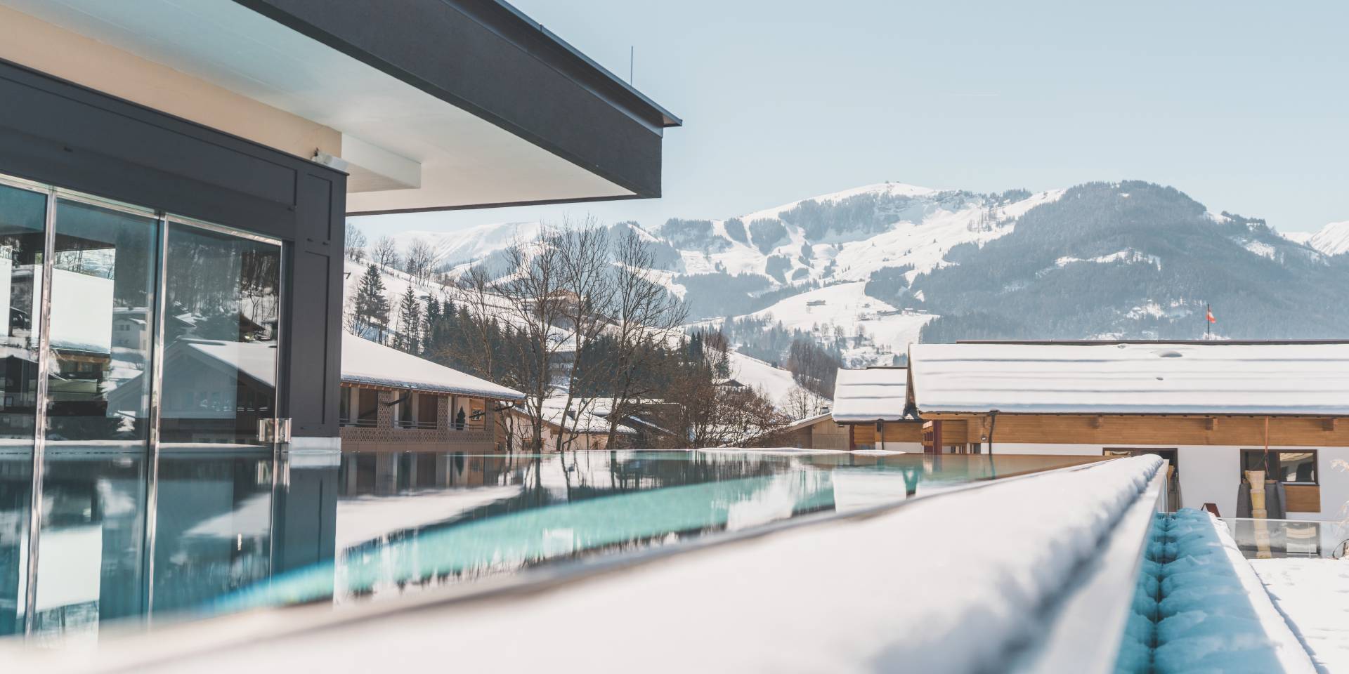 Infinity pool with view of the snow-capped mountains at the HOCHKÖNIGIN in Maria Alm