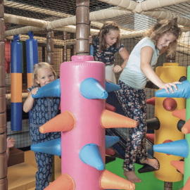 Drei Mädchen spielen fröhlich in der bunten Softplayanlage der FUN ARENA im Hotel die HOCHKÖNIGIN in Maria Alm – Indoor-Spaß für Kinder im Salzburger Land