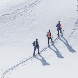 Three ski tourers ascend through untouched snow on the Hochkönig – a serene winter landscape and pure nature experience in Maria Alm.
