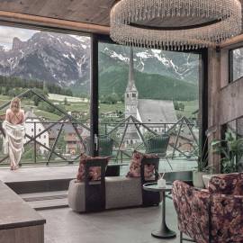 Blick aus dem TIARA SPA im Hotel die HOCHKÖNIGIN in Maria Alm am Hochkönig auf die Dorfkirche und die alpine Berglandschaft – Wellness mit Panorama.