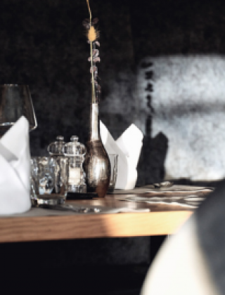 Detailaufnahme eines elegant eingedeckten Tisches mit Vase im Restaurant der HOCHKÖNIGIN in Maria Alm, 4-Sterne-Superior-Hotel im Salzburger Land – stilvolle Tischdeko für genussvolle Momente.