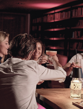 2 Pärchen sitzen bei Cocktails in der HIGH QUEEN BAR vom Hotel die HOCHKÖNIGIN in Maria Alm