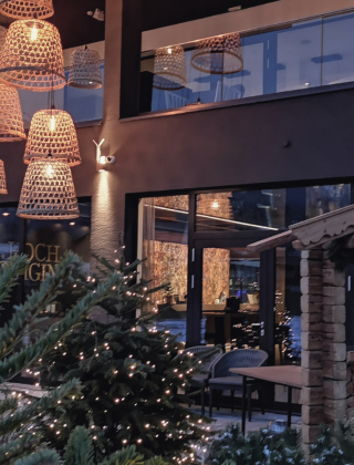 Glühweinstand mit Winterbeleuchtung auf der Terrasse der HOCHKÖNIGIN in Maria Alm mit Blick auf das Hotel