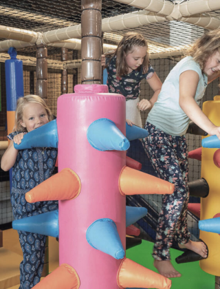 Three girls having fun in the colorful soft play area of the FUN ARENA at Hotel die HOCHKÖNIGIN, Maria Alm – indoor playground excitement in the Salzburg Alps