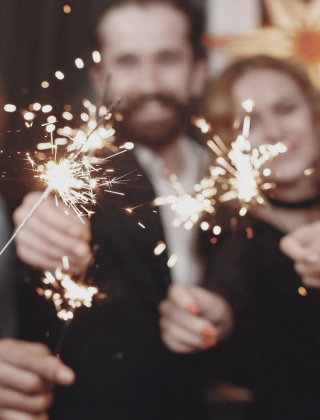 Gruppe von Freunden feiert Silvester mit Wunderkerzen im Hotel die HOCHKÖNIGIN.