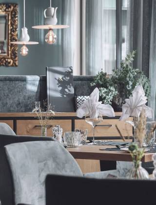 Modern und edel eingerichteter Restaurantbereich im Hotel die HOCHKÖNIGIN mit stilvoll gedeckten Tischen und gemütlicher Atmosphäre in Maria Alm.