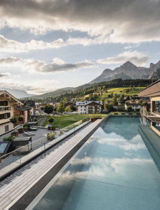 Infinity Outdoor Pool im QUEEN SPA der HOCHKÖNIGIN mit Bergblick in Maria Alm am Hochkönig.