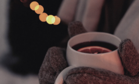 Glühwein in der Hand mit warmen Handschuhen, stimmungsvolle Winterlichter im Hintergrund im Hotel die HOCHKÖNIGIN in Maria Alm
