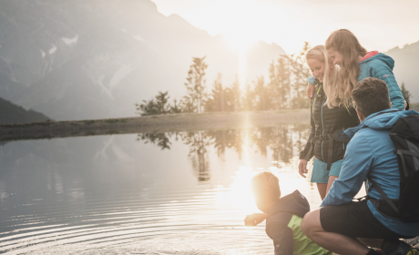 Familie genießt den Sonnenuntergang am Prinzensee in Maria Alm im Salzburger Land – Hotel die HOCHKÖNIGIN