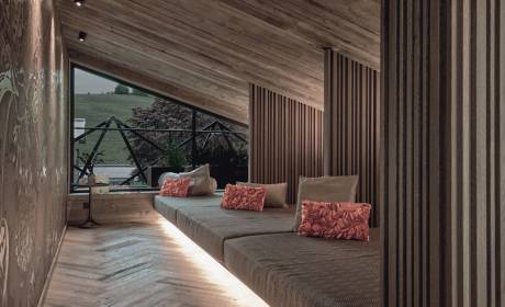 Stilvoller Ruheraum im TIARA SPA des Hotels die HOCHKÖNIGIN in Maria Alm am Hochkönig mit gemütlichen Liegen, warmem Holzdesign und Blick auf die Berglandschaft.