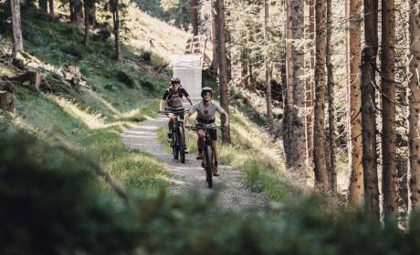Zwei Mountainbiker fahren auf einem Waldtrail in Maria Alm am Hochkönig – Bikeurlaub und Naturerlebnis im Salzburger Land nahe dem Hotel HOCHKÖNIGIN.