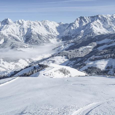 Winter panorama on the Hochkönig overlooking the Maria Alm ski area – snow-covered slopes, bright sunshine and the majestic peaks of the Alps make this winter holiday in Salzburg unforgettable.