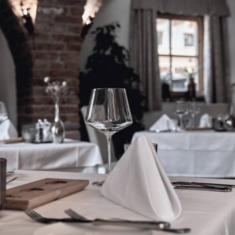 Elegantly set table in the gourmet restaurant of Hotel die HOCHKÖNIGIN, offering fine dining and refined culinary experiences in Maria Alm, Austria.