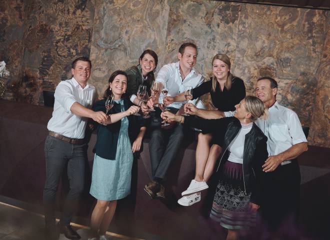 The Hörl family toasting with a glass of champagne in the stylish atrium of Hotel die HOCHKÖNIGIN