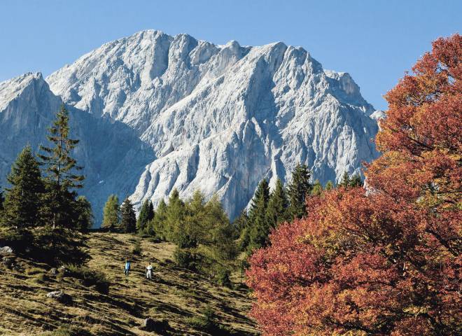 Herbst in der Region Hochkönig mit Wanderern, bunten Bäumen und Bergen im Hintergrund