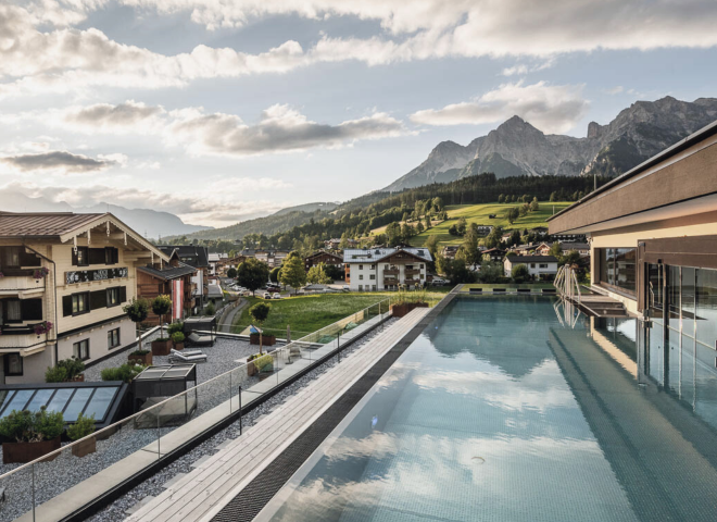 Infinitypool und Whirlpool auf der Dachterrasse des Hotels die HOCHKÖNIGIN in Maria Alm mit Blick auf das Steinerne Meer bei stimmungsvoller Abenddämmerung