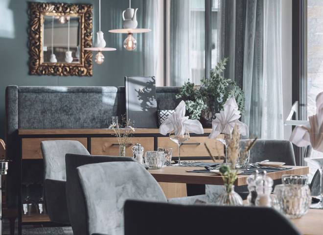 Modern und edel eingerichteter Restaurantbereich im Hotel die HOCHKÖNIGIN mit stilvoll gedeckten Tischen und gemütlicher Atmosphäre in Maria Alm.