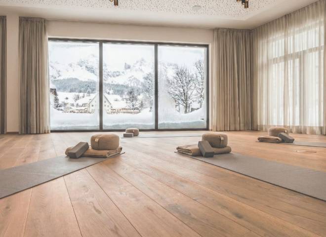 Yoga- und Bewegungsraum im Hotel die HOCHKÖNIGIN in Maria Alm mit Panorama-Blick auf die verschneiten Berge im Salzburger Land.