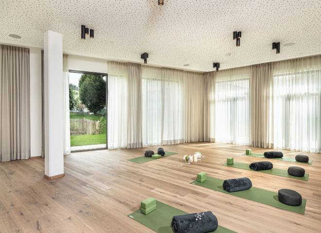 Heller Yogaraum im Hotel die HOCHKÖNIGIN in Maria Alm mit Yogamatten und Blick ins Grüne – ideal für Yoga und Entspannung im Hochkönig-Gebiet.