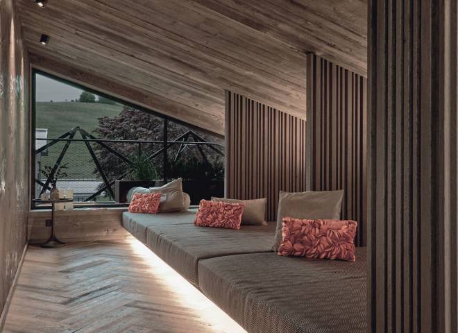 Stilvoller Ruheraum im TIARA SPA des Hotels die HOCHKÖNIGIN in Maria Alm am Hochkönig mit gemütlichen Liegen, warmem Holzdesign und Blick auf die Berglandschaft.