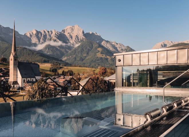 Infinitypool im TIARA SPA der HOCHKÖNIGIN mit Panoramablick auf Maria Alm, die Wallfahrtskirche und das Hochkönig-Massiv.