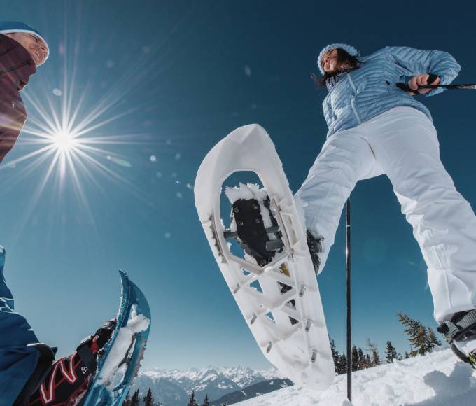 Couple snowshoeing in the snowy winter landscape in the mountains in Salzburger Land
