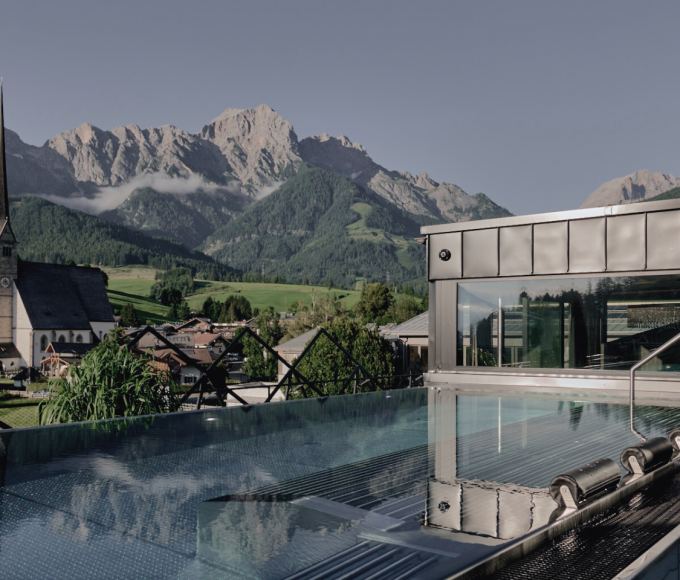 Rooftop Pool mit Bergblick und Blick auf die Kirche von Maria Alm in der HOCHKÖNIGIN