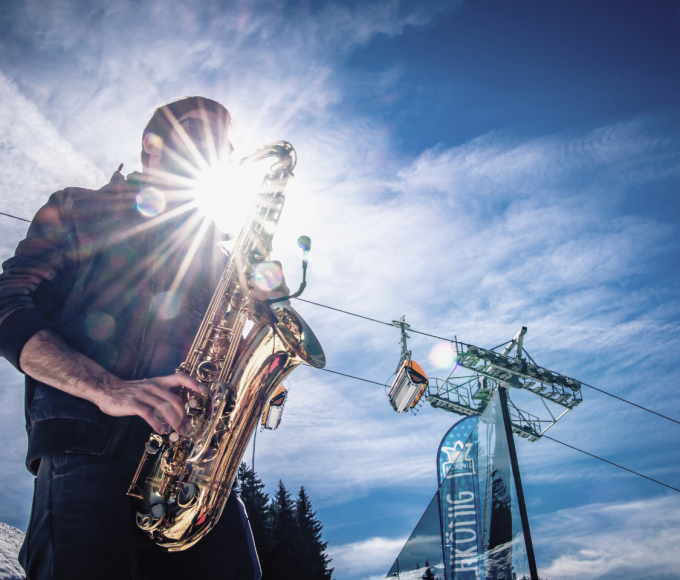 Saxophonist on the mountain in the snow
