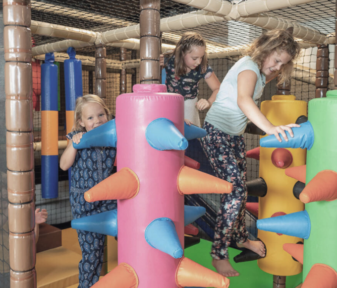 Drei Mädchen spielen fröhlich in der bunten Softplayanlage der FUN ARENA im Hotel die HOCHKÖNIGIN in Maria Alm – Indoor-Spaß für Kinder im Salzburger Land