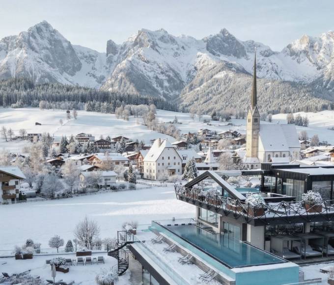 Winterpanorama von Maria Alm am Hochkönig mit dem Wellnesshotel die HOCHKÖNIGIN, verschneitem Bergdorf, Kirche und alpiner Bergkulisse im Salzburger Land – exklusiver Winterurlaub, Wellnesshotel in Maria Alm, Österreichische Alpen