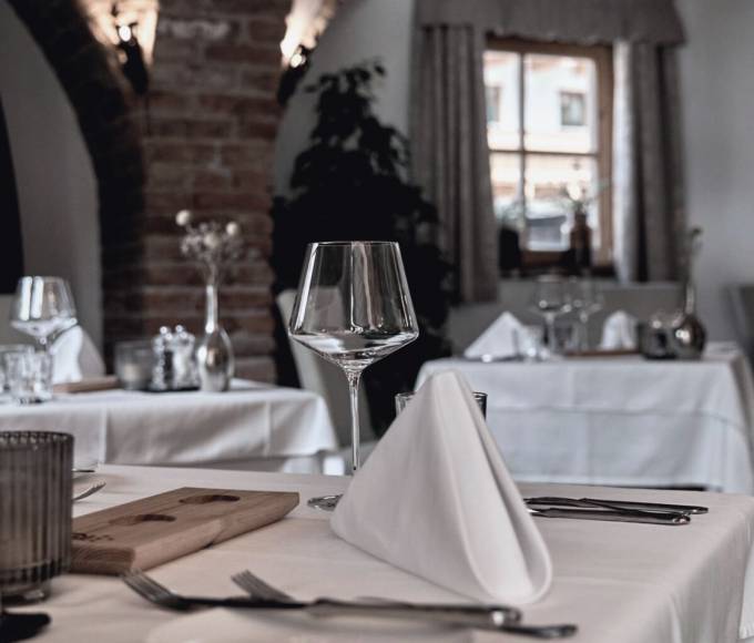 Stilvoll gedeckter Tisch im Gourmetrestaurant des Hotels die HOCHKÖNIGIN mit eleganter Atmosphäre und hochwertiger Kulinarik in Maria Alm.