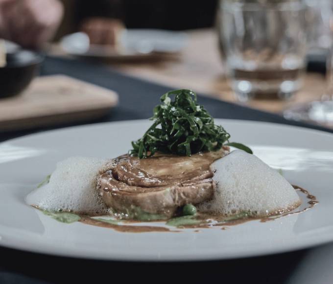 Artfully plated gourmet dish from the award-winning cuisine at Hotel die HOCHKÖNIGIN in Maria Alm, Austria, served in an elegant restaurant setting.