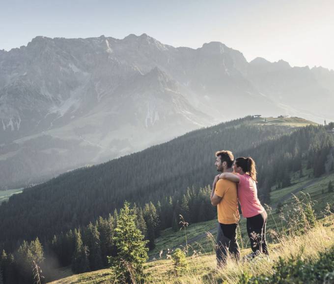 Hiking couple with a view of the Hochkönig near Maria Alm – hiking vacation on the Hochkönig in the Salzburg Alps