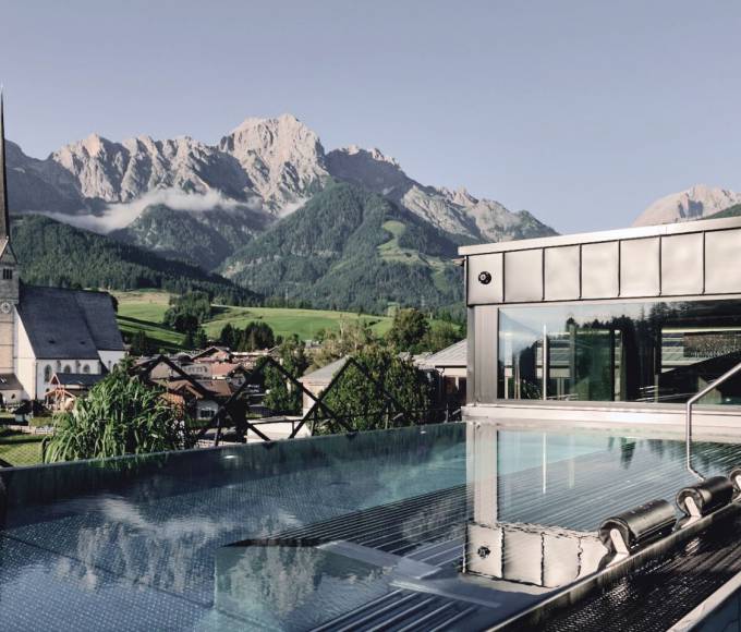 Infinity pool with view of Maria Alm and the Hochkönig mountains at wellness hotel die HOCHKÖNIGIN