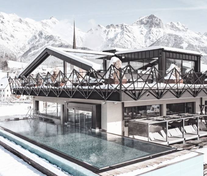 Infinity Pool im TIARA SPA des Wellnesshotels die HOCHKÖNIGIN in Maria Alm am Hochkönig mit Panoramablick auf die verschneiten Berge des Salzburger Landes.