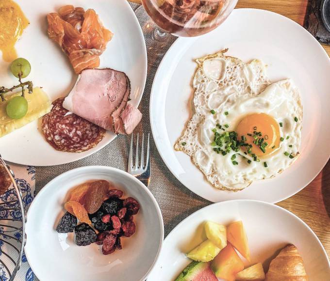 Reichhaltiges Frühstück mit regionalen Produkten im Hotel die HOCHKÖNIGIN in Maria Alm am Hochkönig – frisches Gebäck, Käse, Schinken, Spiegelei und Kaffee für einen genussvollen Start in den Urlaubstag.