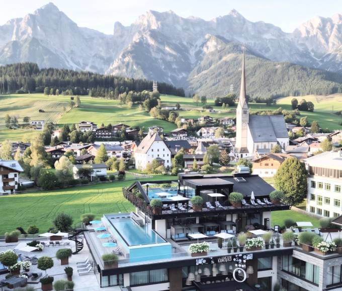 Infinitypool im TIARA SPA des Wellnesshotels die HOCHKÖNIGIN in Maria Alm mit Blick auf die Kirche und das Hochkönig-Gebirge.