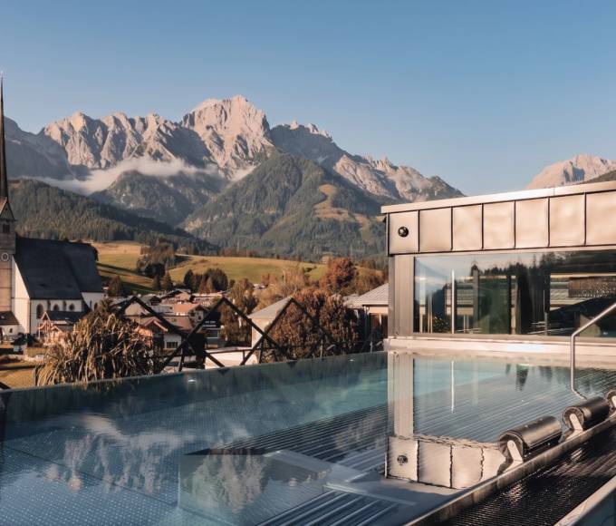 Infinitypool im TIARA SPA der HOCHKÖNIGIN mit Panoramablick auf Maria Alm, die Wallfahrtskirche und das Hochkönig-Massiv.