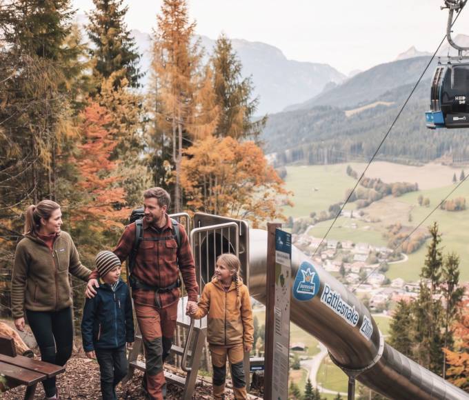 Familie am Erlebnisberg Natrun beim Einstieg in den Waldrutschenpark mit Sommerrodelbahn und Bergbahn in Maria Alm am Hochkönig.