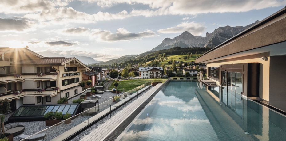 Infinity pool and whirlpool on the rooftop of Hotel die HOCHKÖNIGIN in Maria Alm with sunset views of the Steinernes Meer mountains