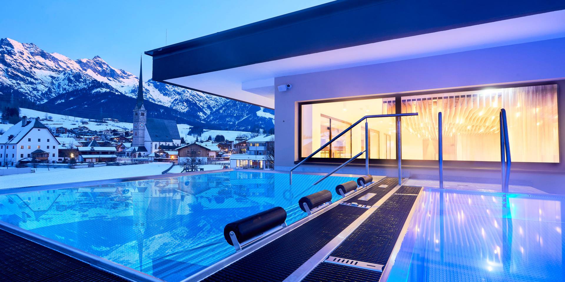 Außenpool mit Blick auf Maria Alm bei Nacht