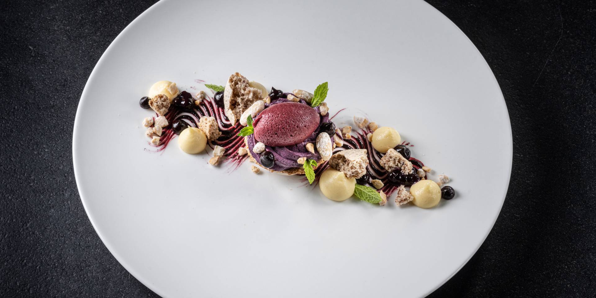 Dessert mit Beeren angerichtet auf einem weissen Teller