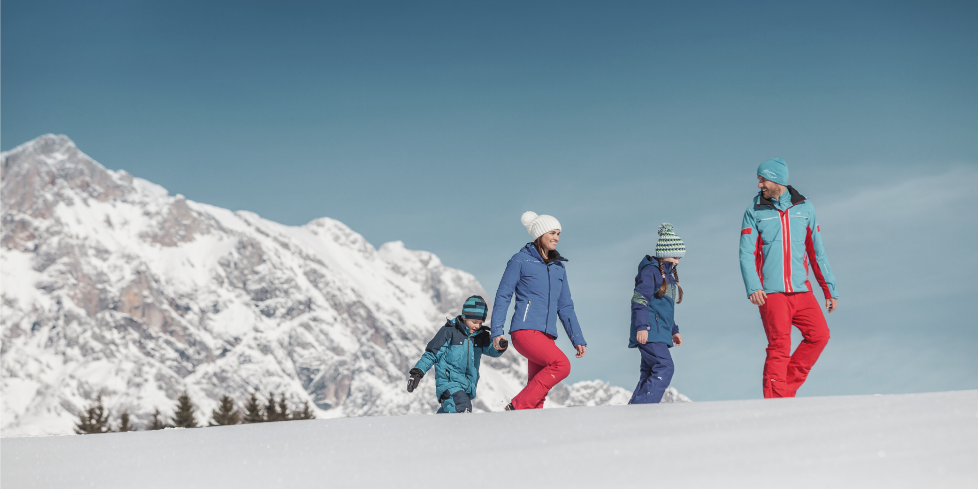 Family on a winter hike in the snow-covered winter landscape in the mountains of Salzburger Land