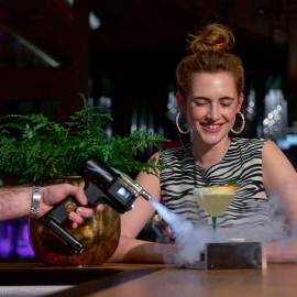 Frau an Hotelbar erhält ein Getränk