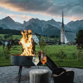 Hotel terrace with fire bowl at the HOCHKÖNIGIN in Maria Alm Hochkönig Salzburgerland with view of the Steinerne Meer