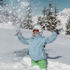 Kind in den Bergen bei schönem Schnee und Sonnenschein