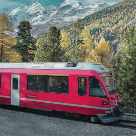 Red railway runs through mountain landscape