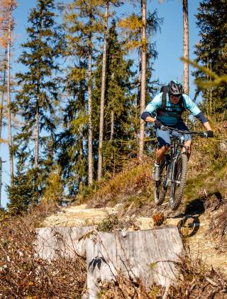 Mountainbiker fährt Waldpfad im Pinzgau entlang