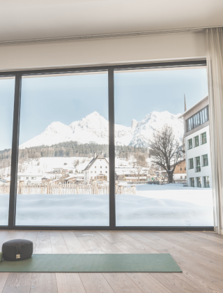 Fitness room with yoga mat in light colours