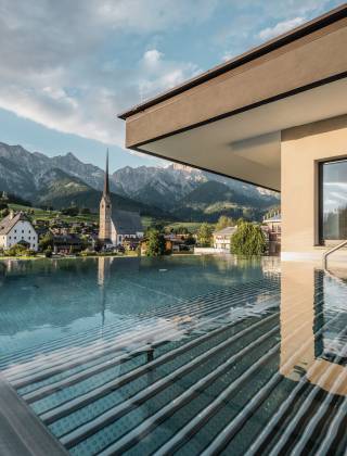 Outdoor pool the HOCHKÖNIGIN during the day in Maria Alm Wellnesshotel Luxury Hotel Family Hotel